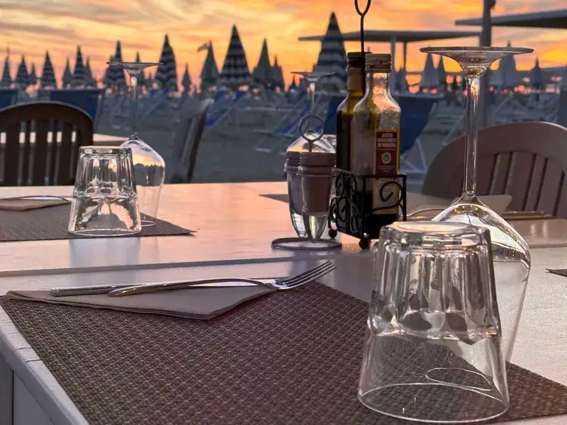 Un tavolo apparecchiato al tramonto sulla spiaggia