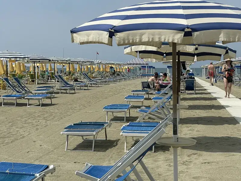 Ombrelloni a righe e lettini sulla spiaggia del Bagno Amedea