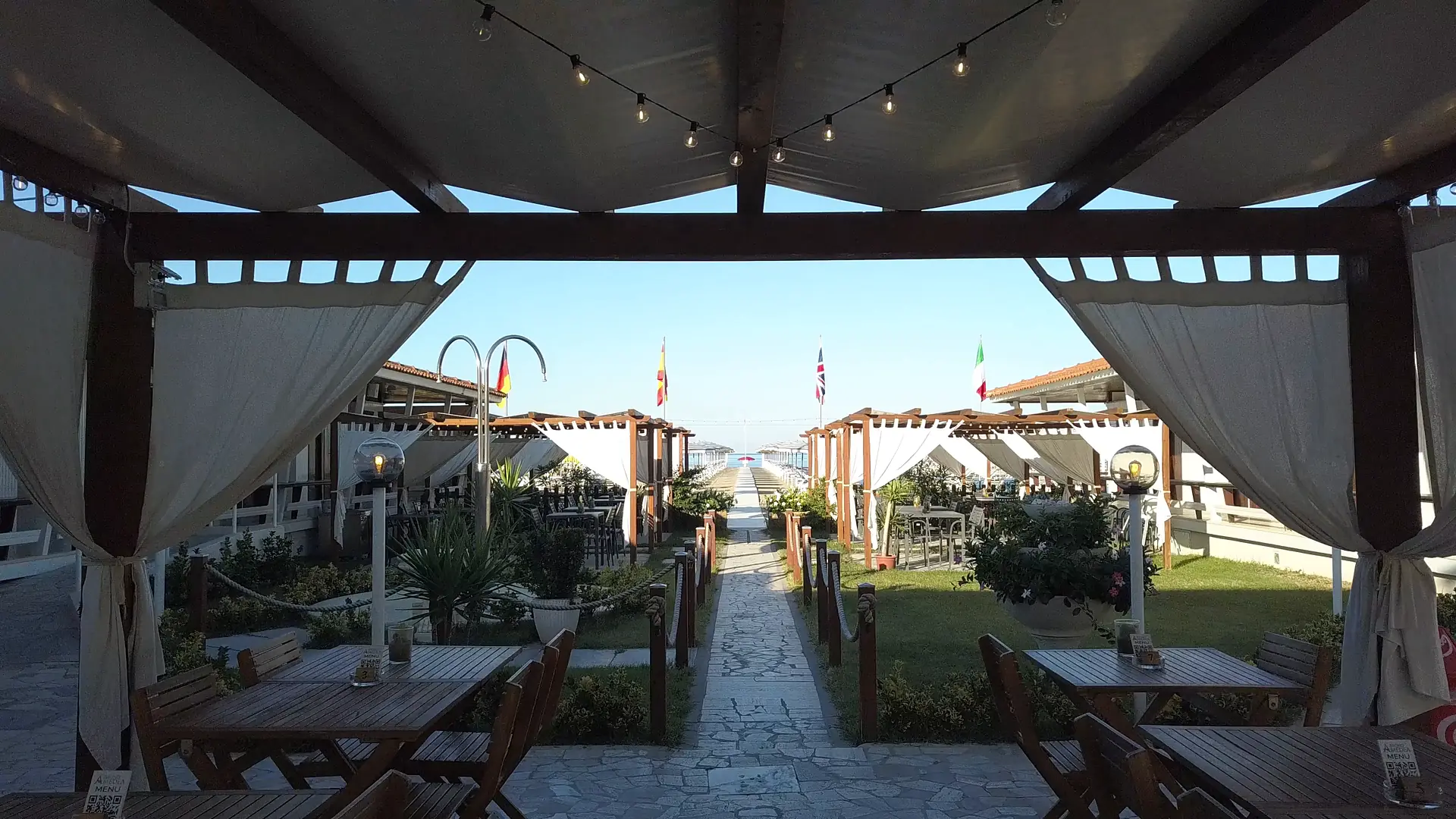 Il giardino del Bagno Amedea sotto il pergolato, con il vialetto verso il mare